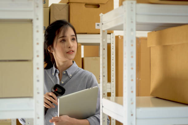 istock A beautiful Asian woman uses a barcode reader to check stock in a warehouse. 1338472603