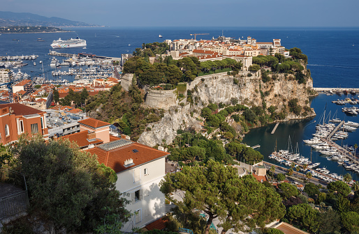 April 30, 2023: This photo shows the glamorous and luxurious principality of Monaco, nestled on the stunning French Riviera. The image captures a panoramic view of the cityscape, featuring the towering hillside, opulent architecture, and the Mediterranean Sea. The photo is also adorned with the yachts moored in the harbor.