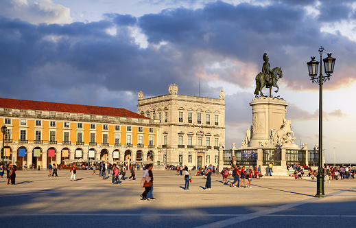 Lisbon, Portugal. Central Commercial square area with monument in honor of King Jose. Evening sunset with blue sky and clouds. Walking tourists in downtown, Historical centre of old town of Lisboa.