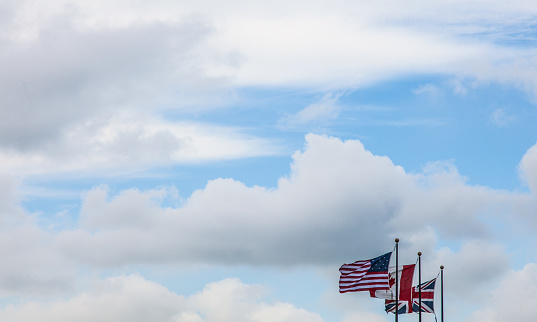 A closeup shot of an American flag in front of a bright afternoon sky