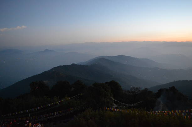 Tiger Hill Darjeeling At sunrise, the peaks of Kanchenjunga are illuminated before the sun is seen at lower elevations. From Tiger Hill, Mount Everest (8848 m) is just visible. Kanchenjunga (8598 m) looks higher than Mt. Everest, owing to the curvature of the Earth, as it is several miles closer than Everest. The distance in a straight line from Tiger Hill to Everest is 107 miles (172 km).
On a clear day, Kurseong is visible to the south and in the distance, along with Teesta River, Mahananda River, Balason River and Mechi River meandering down to the south. Chumal Rhi mountain of Tibet, 84 miles (135 km) away, is visible over the Chola Range
Senchel Wildlife Sanctuary is close to Tiger Hill. tiger hill stock pictures, royalty-free photos & images