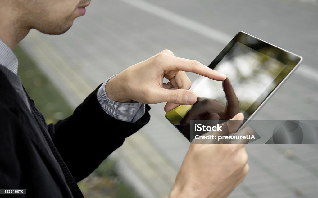 Un hombre de negocios utilizando Tablet con pantalla táctil - Foto de stock de 25-29 años libre de derechos