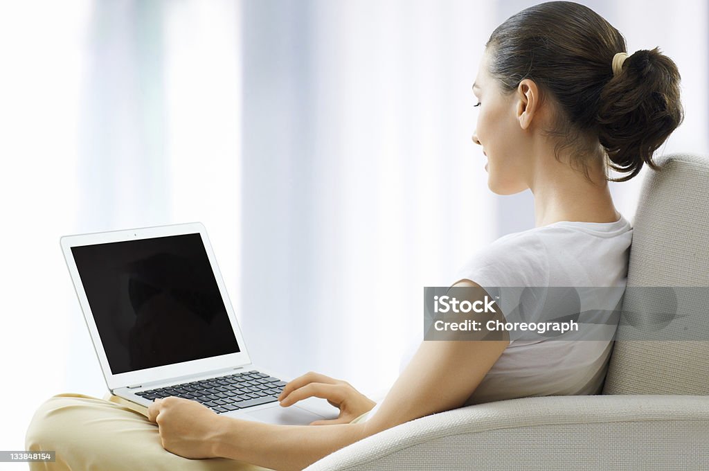 working in a laptop Girl working on computer in light room Adult Stock Photo