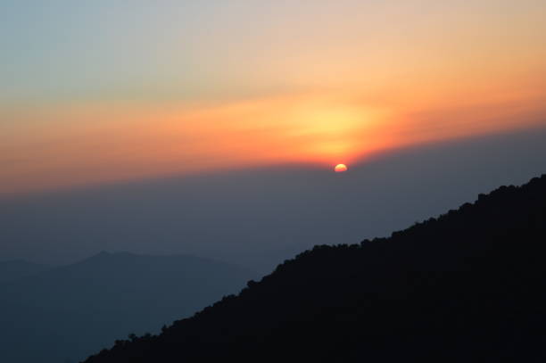 Sunrise at Tiger Hill Darjeeling At sunrise, the peaks of Kanchenjunga are illuminated before the sun is seen at lower elevations. From Tiger Hill, Mount Everest (8848 m) is just visible. Kanchenjunga (8598 m) looks higher than Mt. Everest, owing to the curvature of the Earth, as it is several miles closer than Everest. The distance in a straight line from Tiger Hill to Everest is 107 miles (172 km).
On a clear day, Kurseong is visible to the south and in the distance, along with Teesta River, Mahananda River, Balason River and Mechi River meandering down to the south. Chumal Rhi mountain of Tibet, 84 miles (135 km) away, is visible over the Chola Range
Senchel Wildlife Sanctuary is close to Tiger Hill. tiger hill stock pictures, royalty-free photos & images