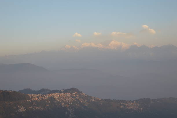 Tiger Hill Darjeeling At sunrise, the peaks of Kanchenjunga are illuminated before the sun is seen at lower elevations. From Tiger Hill, Mount Everest (8848 m) is just visible. Kanchenjunga (8598 m) looks higher than Mt. Everest, owing to the curvature of the Earth, as it is several miles closer than Everest. The distance in a straight line from Tiger Hill to Everest is 107 miles (172 km).
On a clear day, Kurseong is visible to the south and in the distance, along with Teesta River, Mahananda River, Balason River and Mechi River meandering down to the south. Chumal Rhi mountain of Tibet, 84 miles (135 km) away, is visible over the Chola Range
Senchel Wildlife Sanctuary is close to Tiger Hill. tiger hill stock pictures, royalty-free photos & images