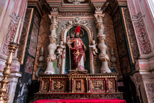 Modica , sicily, italy, june 19, 2018 : altar and choir of a lateral chapel with statue of a saint  in the nave of San Pietro church