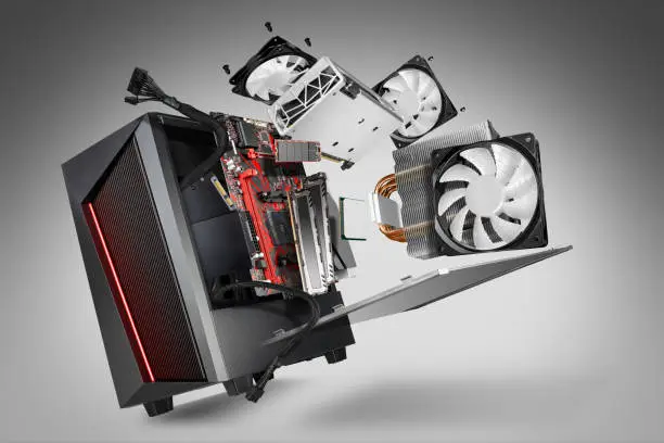 Photo of exploded view of a modern computer. hardware components mainboard cpu processor graphic card RAM cables and cooling fan flying out of black red PC case gray abstract technology concept background