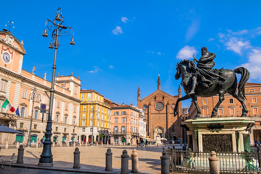 People strolling in Piazza Cavalli, the central square of Piacenza, where stand out the Cavalli dei Mochi, two bronze horses created by the Tuscan sculptor Francesco Mochi da Montevarchi and dating back to the seventeenth century.