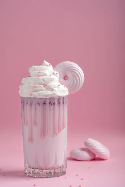 szklanka słodkiego koktajlu mlecznego z bitą śmietaną ozdobiona bezą na różowym tle - cream sprinkles food and drink freshness zdjęcia i obrazy z banku zdjęć