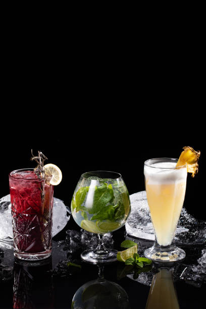 istock Set of different cocktails on black background with ice cubes 1338488829