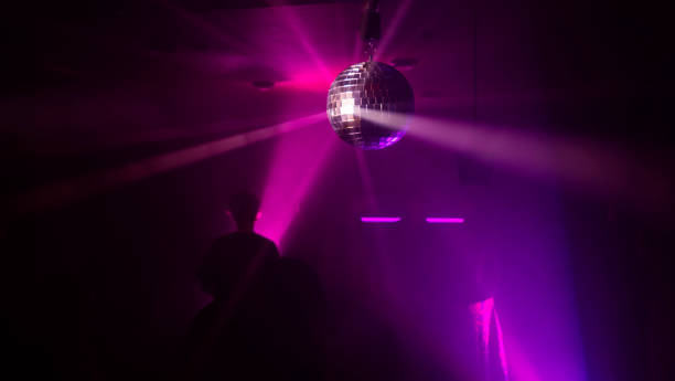 istock Party atmosphere with disco ball. Light beams reflecting from a disco ball. Nightlife concept. Space for text. 1338490557
