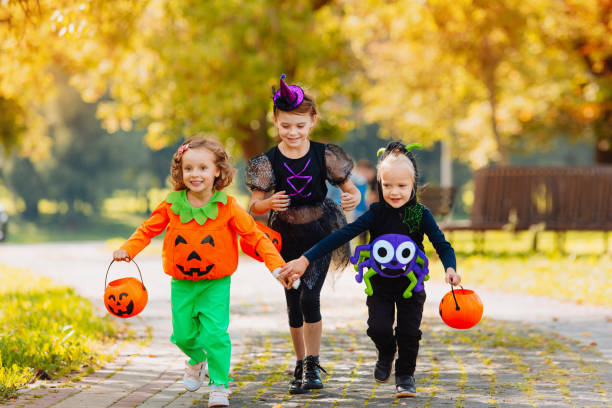 istock Happy Halloween. three running kids with a basket for sweets 1338495506