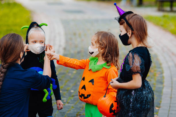 istock Mother putting protective face mask on her child during COVID-19 on Halloween 1338495594