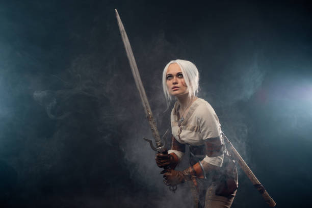 istock A young warrior with a sword on a dark background. Fantasy heroine 1338495658