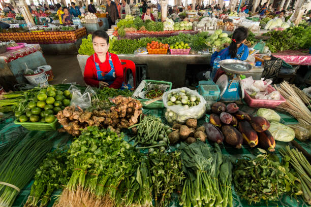 Cambodian women selling fresh fruits and vegetables on a local market in Siem Reap, Cambodia