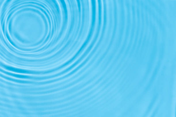istock Waves from drops on blue water under the sun. Top view, flat lay 1338501815