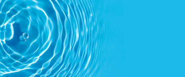 istock Wave from a drop of water on blue water under natural light. Top view, flat lay 1338502592