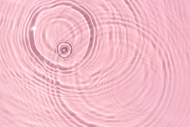 istock Texture wave from drops on pink water under sunlight. Top view, flat lay 1338502643