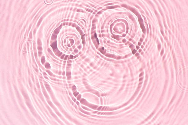 istock Texture of drops on pink water under sunlight. Top view, flat lay 1338502655