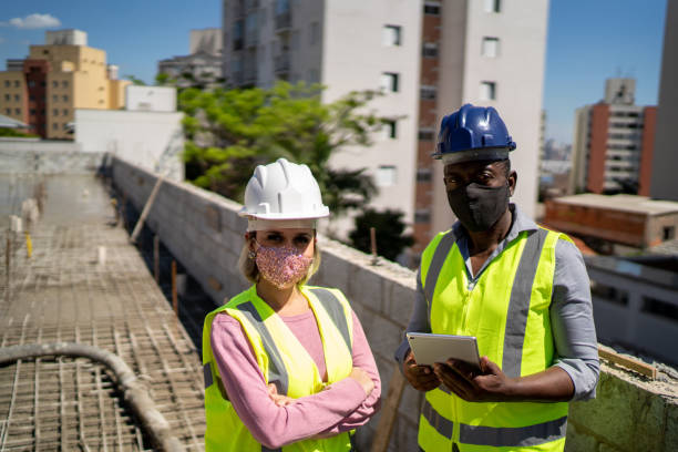 istock Portrait of an engineer and a constructor at a construction site - wearing protective face mask 1338502713