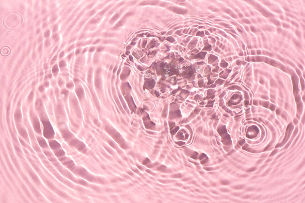 istock Texture of drops on pink water under sunlight. Top view, flat lay 1338502992