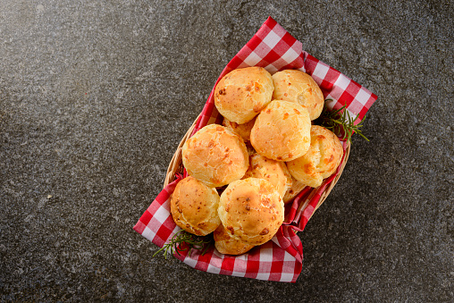 Detail of cheese bread on concrete table photographed in studio. Brazilian snack cheese bread.