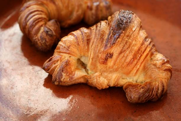 istock Two croissant pastries over orange clay 1338506873