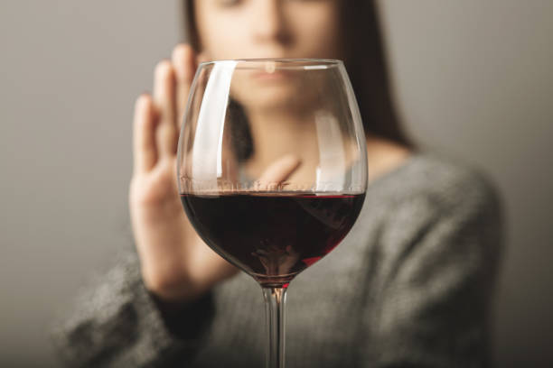 rechazar el licor, dejar de beber alcohol, la adolescente muestra un signo de rechazo del vino - bebida alcohólica fotografías e imágenes de stock