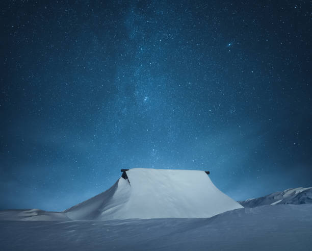 istock Snowcapped Wooden Hut Under The Starry Sky 1338509890