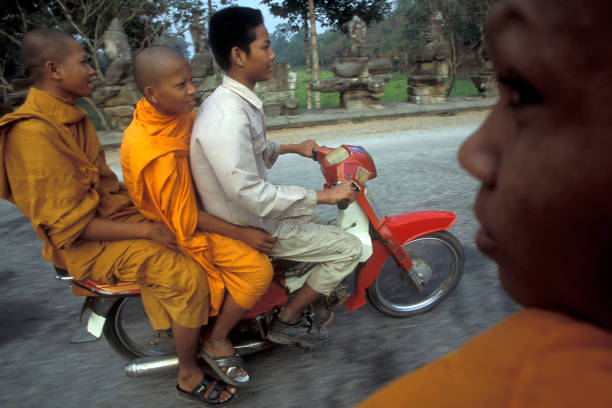 monks on a motorbike in the Temple City of Angkor near the City of Siem Reap in the west of Cambodia.  Cambodia, Siem Reap, February, 2001