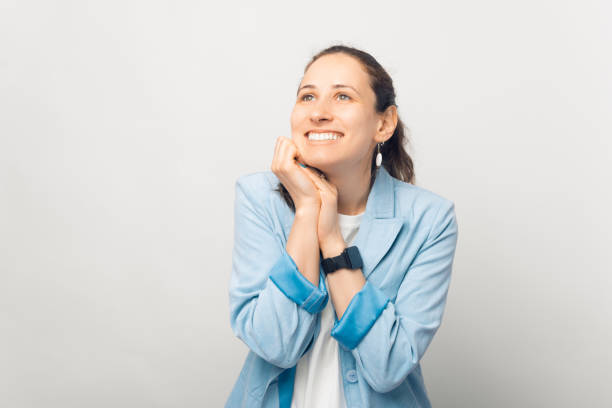 istock Dreamy girl is holding hands together and looking up. 1338512833