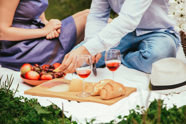 istock Romantic dinner outdoors. Glasses with red wine, grapes and cheese on wooden board. 1338514228