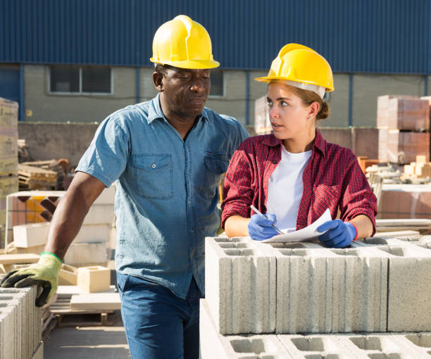istock Manager and employee check documents and construction materials at the open-air site of construction store 1338517000