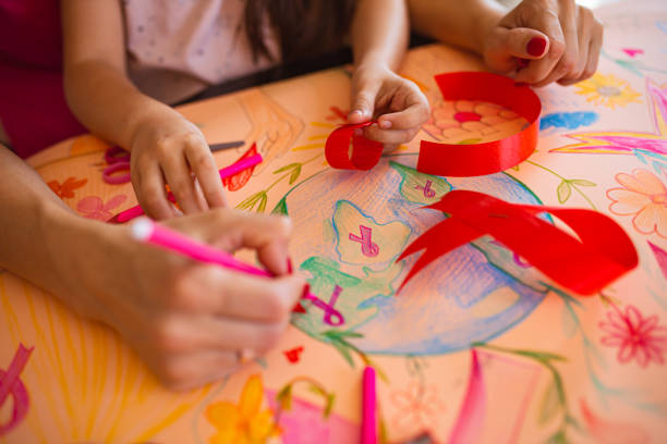 mother using creative time to teaches her daughter about breast cancer awareness - community outreach connection child paper imagens e fotografias de stock