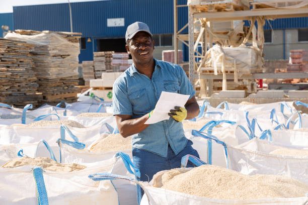 istock Man standing amongst bags in construction material storage 1338517668