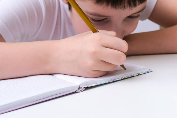 istock A caucasian boy doing his homework at home, he is focused, concentrated while writing in a notebook 1338521236