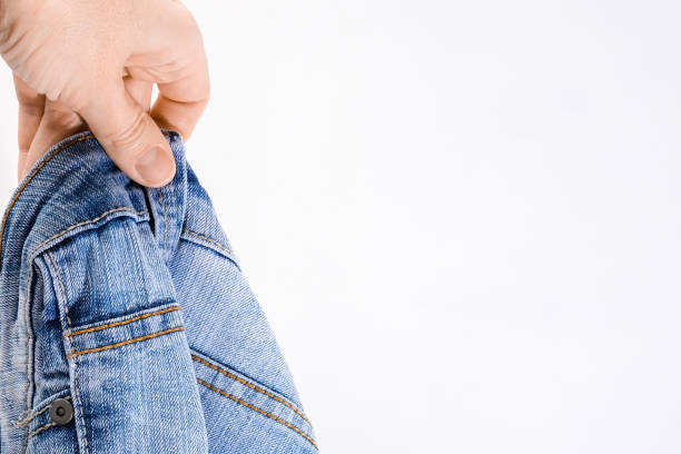 istock A hand holding used bluejeans on white background with copy space 1338521286