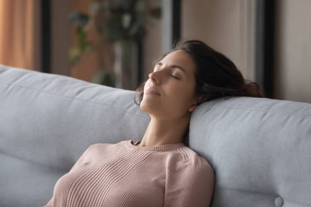istock Closeup peaceful woman fall asleep leaned on comfy sofa cushion 1338521538