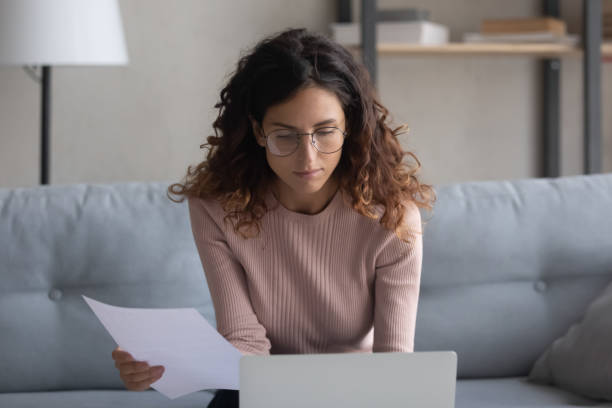 istock Woman holding bills, check documents, makes e-payment use laptop 1338521539