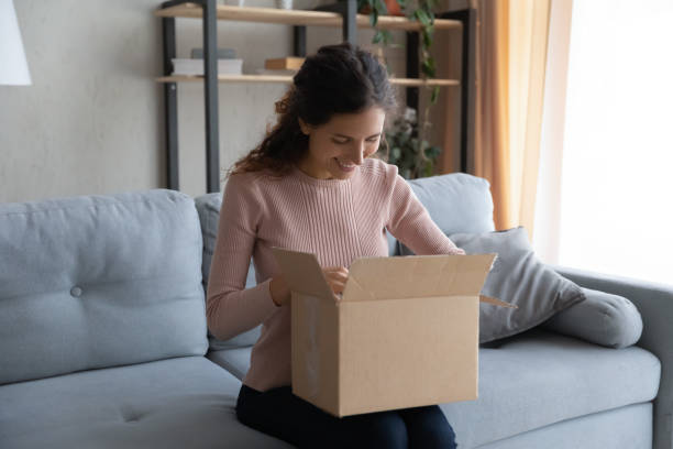 istock Hispanic woman opens parcel feels satisfied with purchased goods 1338521574