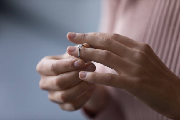 istock Young woman takes off wedding ring, close up view 1338521590