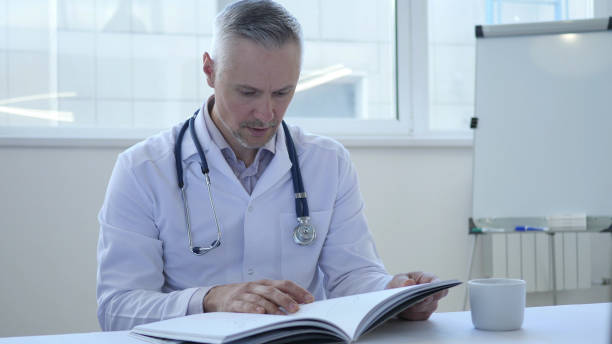 médecin lisant un livre médical en clinique - 16017 photos et images de collection
