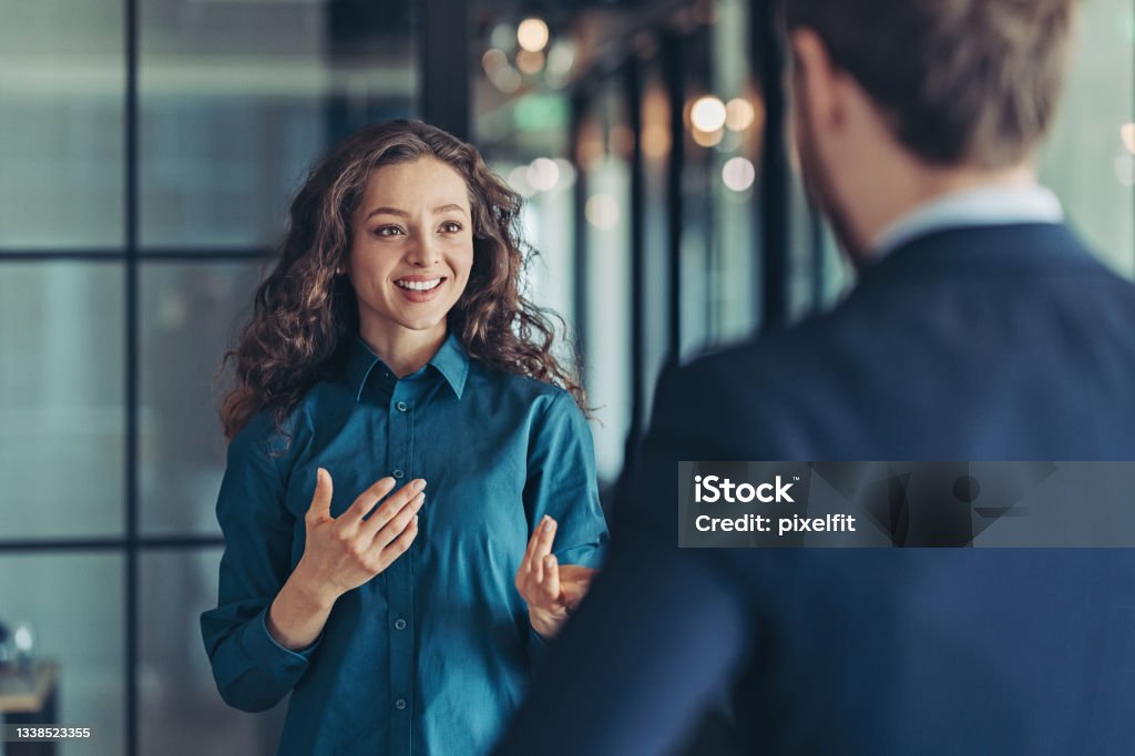 Businesswoman talking to a colleague Businesswoman and businessman talking in the office Discussion Stock Photo