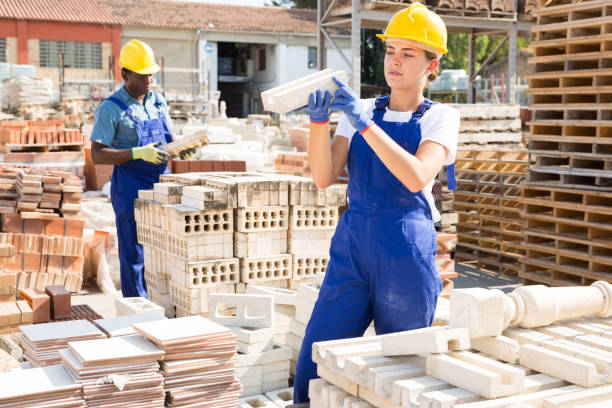 istock Female warehouse employee puts paving slabs on pallet 1338525146