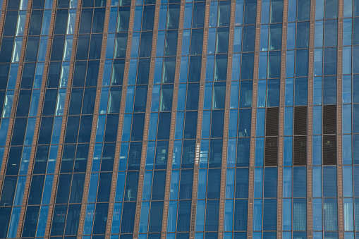 Closeup modern corporate glass building with reflection of the city, background with copy space, full frame horizontal composition