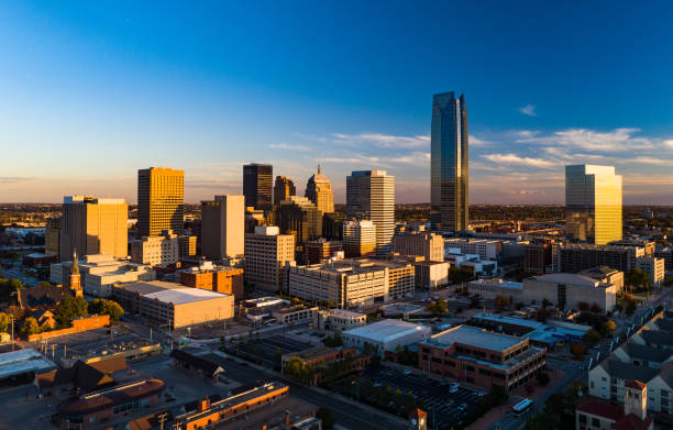 Oklahoma City Skyline Aerial During The Golden Hour Downtown Oklahoma City skyline aerial during the golden hour, with late sun reflections on windows and a blue sky with some clouds in the background. oklahoma city stock pictures, royalty-free photos & images