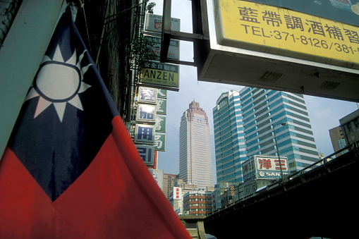 a Taiwan flag with the skyline of the city centre of Taipei in Taiwan of East Aasia.   Taiwan, Taipei, July, 1997