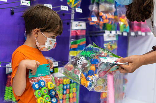 Caucasian Little boy shopping for toys for his piñata birthday party