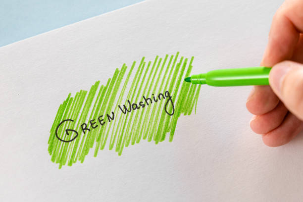 Greenwashing concept. Drawing on paper with text and green marker strokes. Environmental marketing disinformation. Non transparent green sheen. stock photo