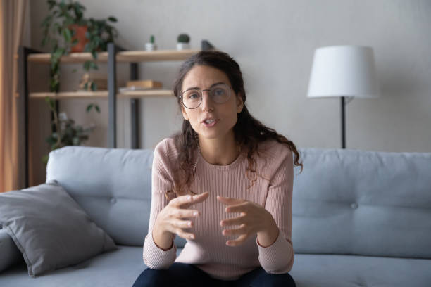 istock Woman sit on sofa at home talking participating in videocall 1338530322